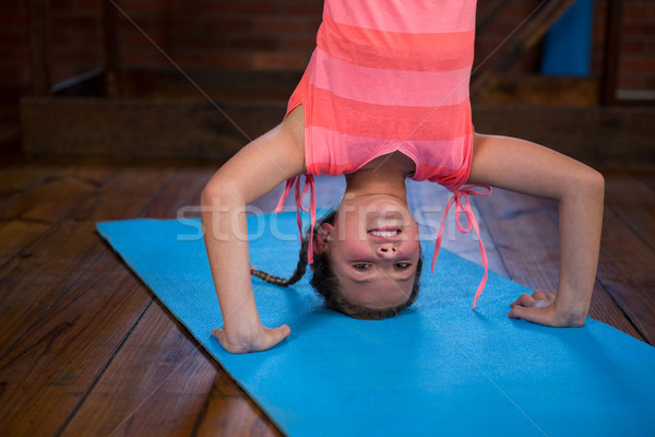 Happy teenage girl performing headstand Stock photo © wavebreak_media
