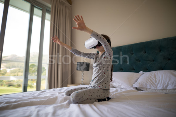 Girl using virtual reality headset on bed Stock photo © wavebreak_media
