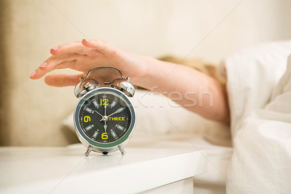 Pretty woman shutting off her alarm clock Stock photo © wavebreak_media