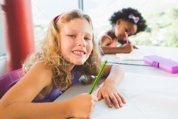 Portrait of girl doing homework in classroom Stock photo © wavebreak_media