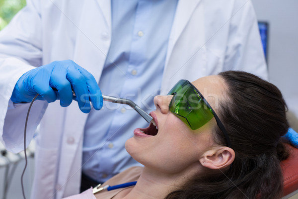 Dentist examining a female patient with dental equipment Stock photo © wavebreak_media