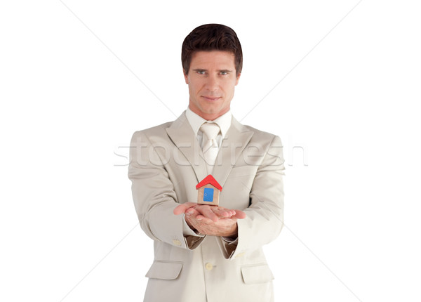 Portrait of a handsome young businessman presenting a sample of house against a white background Stock photo © wavebreak_media