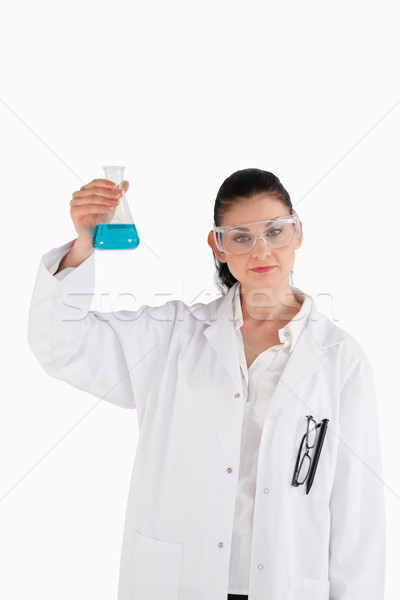 Dark-haired woman holding a blue flask while looking at the camera Stock photo © wavebreak_media