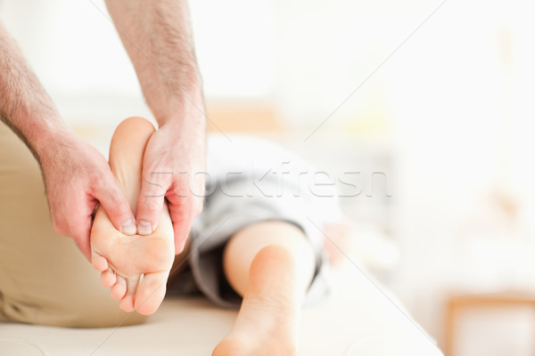 Male masseur massaging a woman's feet in a room Stock photo © wavebreak_media