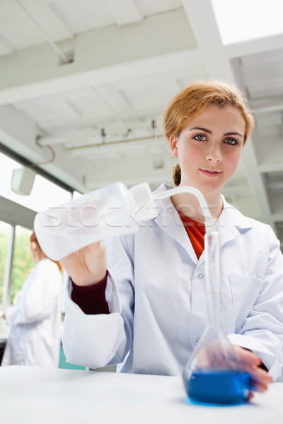 Portrait of a gorgeous scientist pouring liquid in a flask Stock photo © wavebreak_media