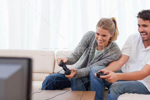 Laughing couple playing video games in their living room Stock photo © wavebreak_media