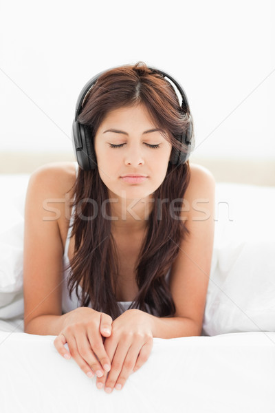 A woman with headphones on listening to music, her eyes closed and her fingers over the lip of the b Stock photo © wavebreak_media