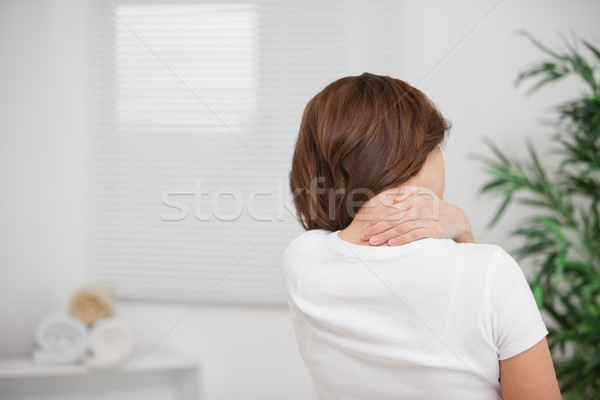 Woman massaging her painful nape indoors Stock photo © wavebreak_media