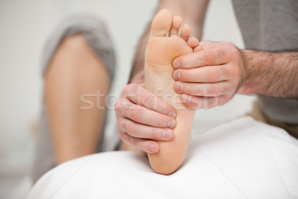 Chiropodist palpating the sole of the foot of a patient in his office Stock photo © wavebreak_media