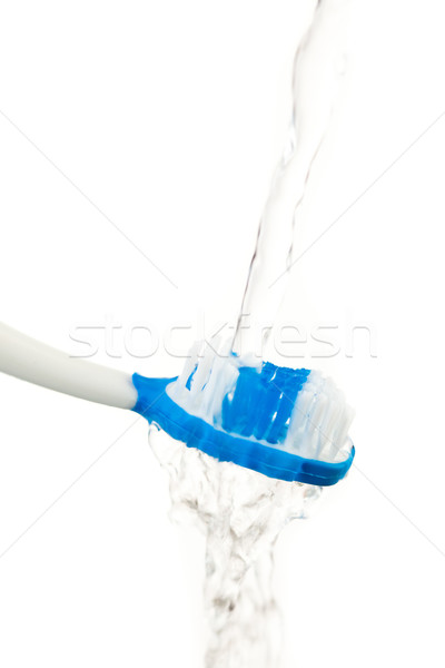 Water flowing on a toothbrush against white background Stock photo © wavebreak_media