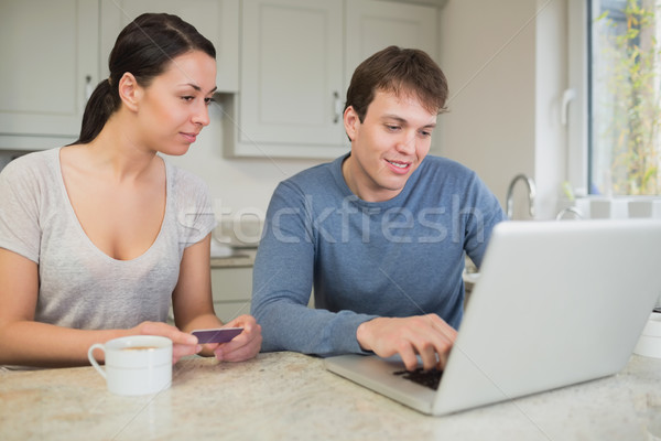 Man showing woman something on laptop in kitchen Stock photo © wavebreak_media