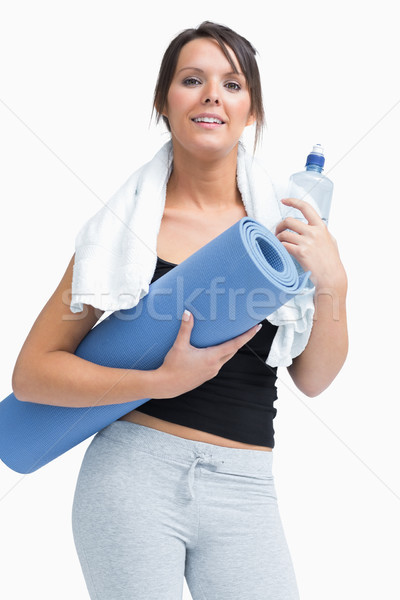 Portrait of woman in sportswear holding water bottle and mat Stock photo © wavebreak_media