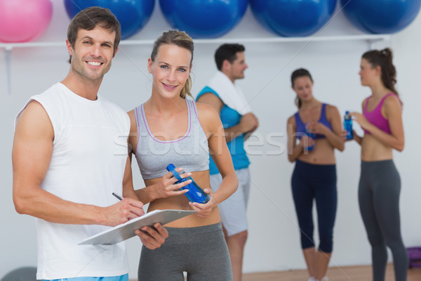 Couple holding clipboard with fitness class in background Stock photo © wavebreak_media