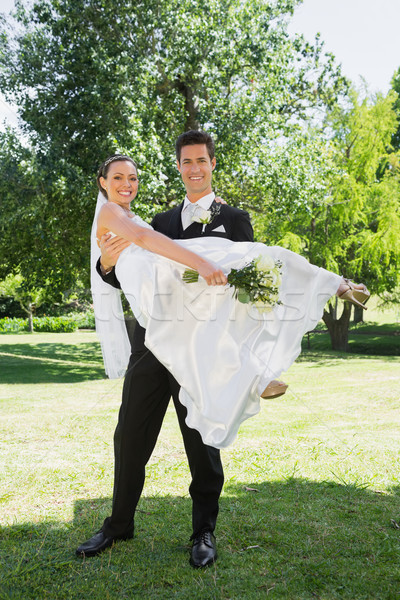 Happy groom lifting bride in arms at garden Stock photo © wavebreak_media