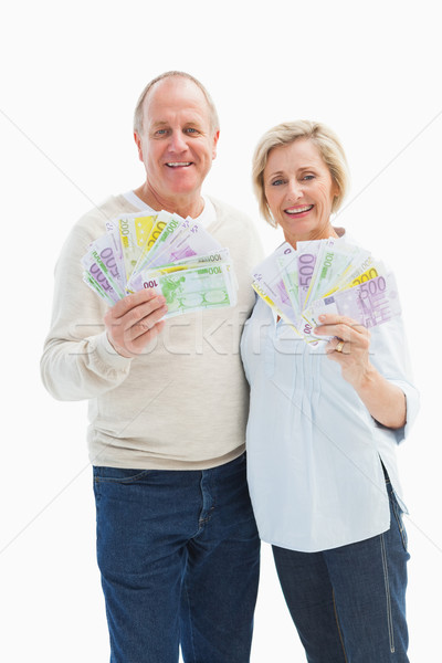 Stock photo: Happy mature couple smiling at camera showing money
