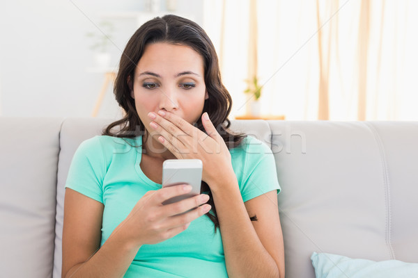 Shocked brunette texting on the phone Stock photo © wavebreak_media