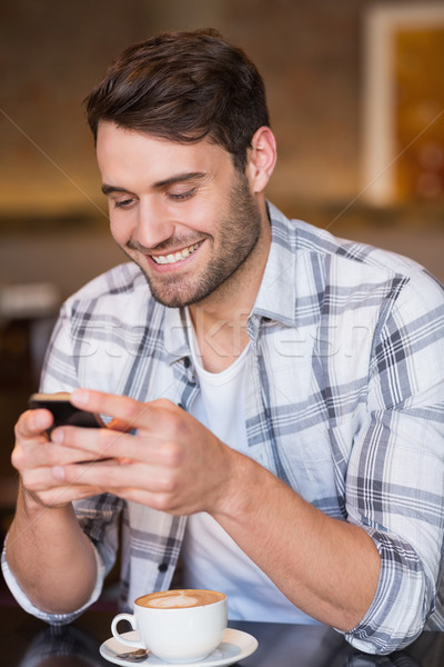 Young man sending a text Stock photo © wavebreak_media