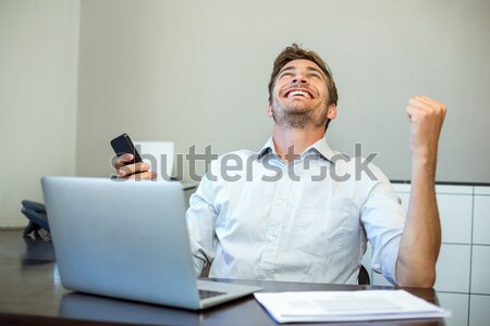 Businessman listening music while playing air guitar in office Stock photo © wavebreak_media