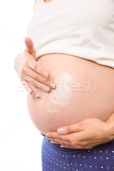 Pregnant woman with cream on bump Stock photo © wavebreak_media