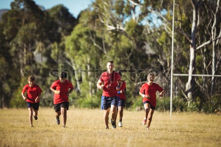 Trainer assisting a boy in obstacle course training Stock photo © wavebreak_media