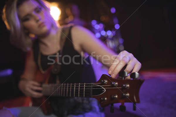 Singer adjusting tuning peg of guitar in nightclub Stock photo © wavebreak_media