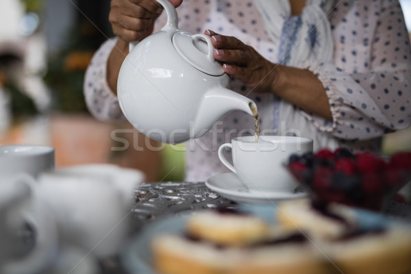 Mid section of woman pouring tea in cup Stock photo © wavebreak_media