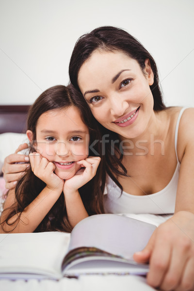 Portrait heureux mère fille livre lit [[stock_photo]] © wavebreak_media
