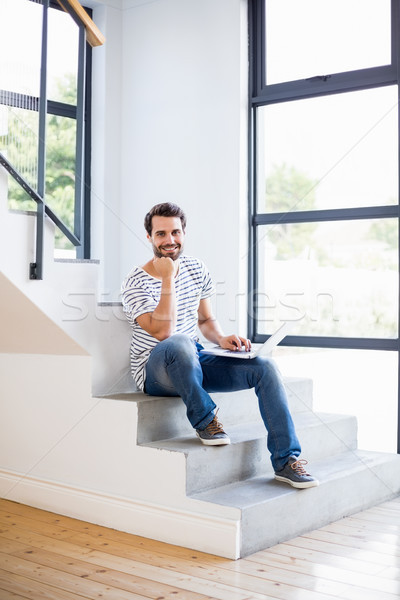 Retrato feliz homem sessão passos usando laptop Foto stock © wavebreak_media