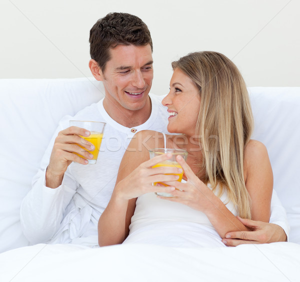 Intimate couple drinking orange juice lying on their bed  Stock photo © wavebreak_media