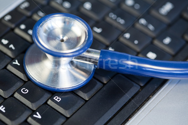Stock photo: Blue angled stethoscope on keyboard on a blue background