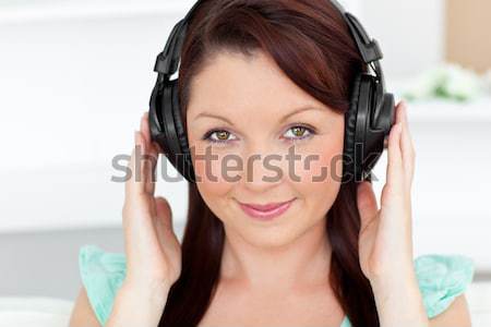 Close up of a smiling woman enjoying some music while looking at the camera Stock photo © wavebreak_media