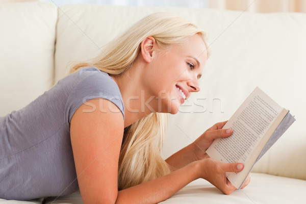 Сток-фото: улыбающаяся · женщина · чтение · книга · гостиной · улыбка · домой