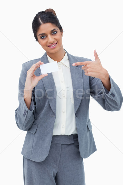 Smiling saleswoman pointing at blank business card against a white background Stock photo © wavebreak_media