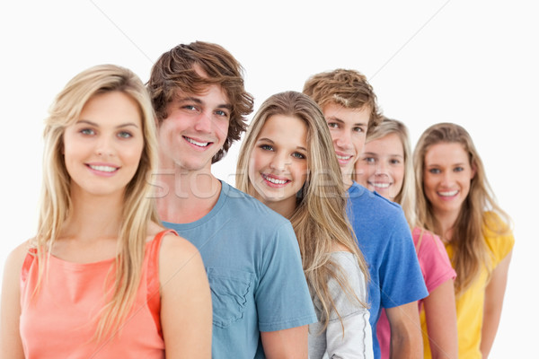 A smiling group standing behind each other at an angle while looking into the camera Stock photo © wavebreak_media