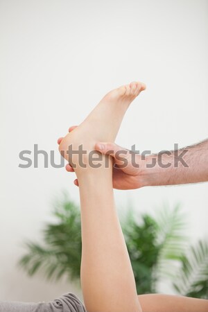 Doctor holding the foot of his patient in a room Stock photo © wavebreak_media