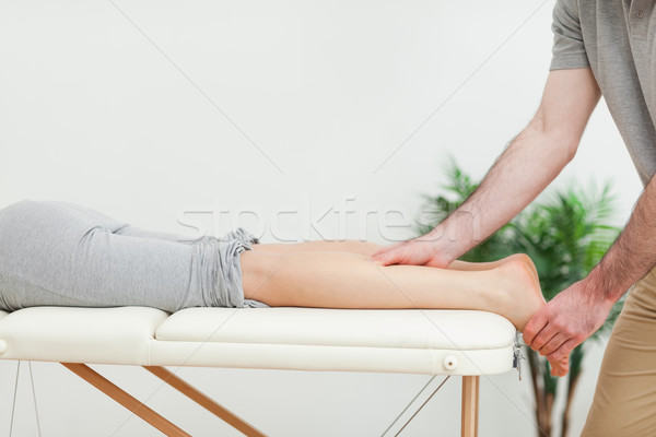 Woman lying while a masseur massaging the calves in a room Stock photo © wavebreak_media