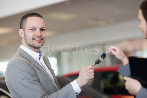 Stock photo: Man holding car keys with a businesswoman in a garage