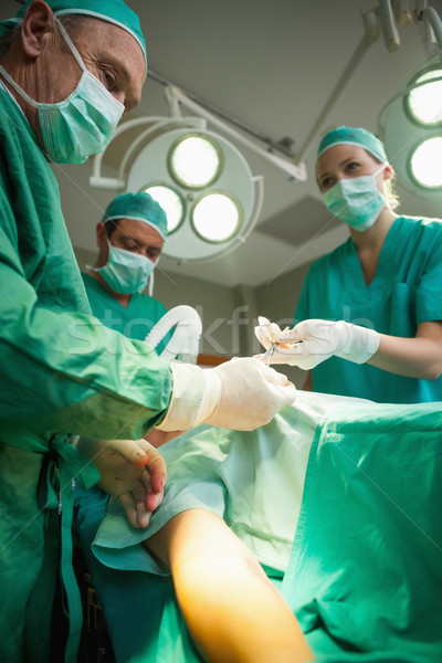 Team of surgeons operating the arm of a patient in a surgical room Stock photo © wavebreak_media