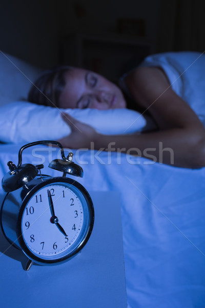 Alarm clock in front of a sleeping woman  Stock photo © wavebreak_media