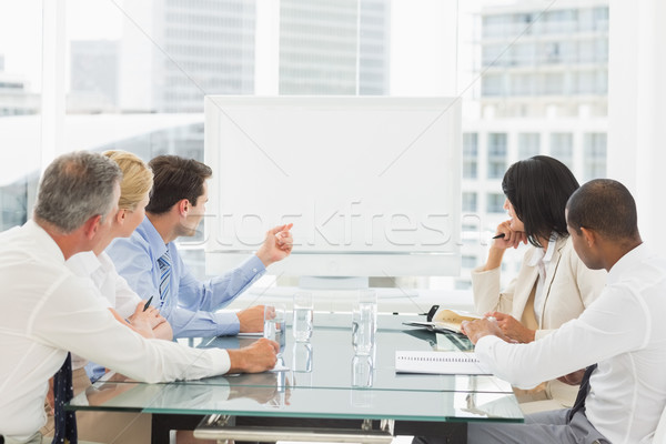 Stock photo: Business people looking at blank whiteboard in conference room