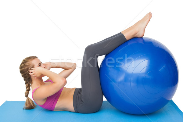 Stock photo: Side view of a fit woman exercising with fitness ball