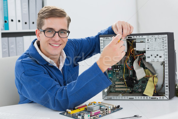 Sorridente técnico trabalhando quebrado computador escritório Foto stock © wavebreak_media