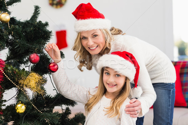 Festive mother and daughter decorating christmas tree Stock photo © wavebreak_media