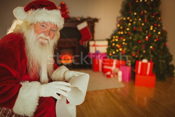 Smiling santa claus holding a scroll Stock photo © wavebreak_media