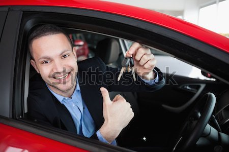 Salesman standing while offering car keys Stock photo © wavebreak_media