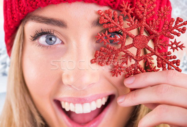 Stock photo: Composite image of happy blonde holding red snowflake