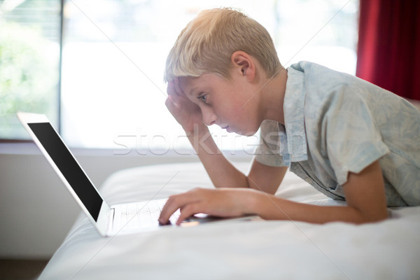 Gespannen jongen met behulp van laptop bed slaapkamer home Stockfoto © wavebreak_media