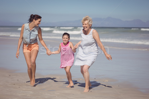 Heureux famille courir mains tenant plage [[stock_photo]] © wavebreak_media