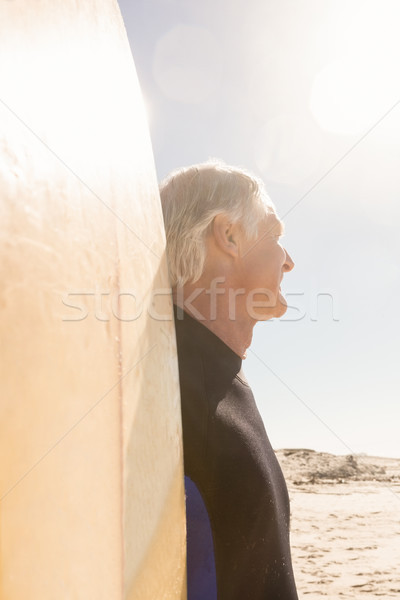 Close up of senior man with surfboard standing against sky Stock photo © wavebreak_media