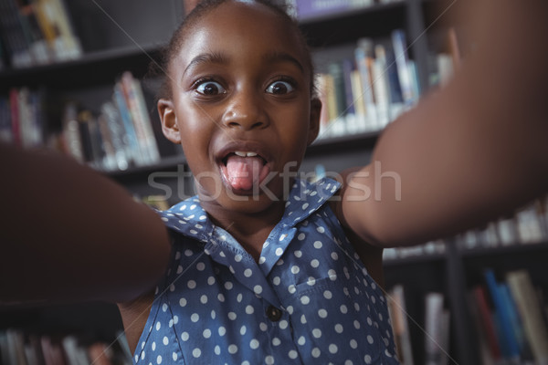 Menina feliz cara biblioteca retrato prateleira de livros Foto stock © wavebreak_media